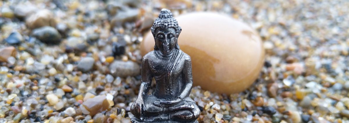 Buddha am Meer zwischen Steinen